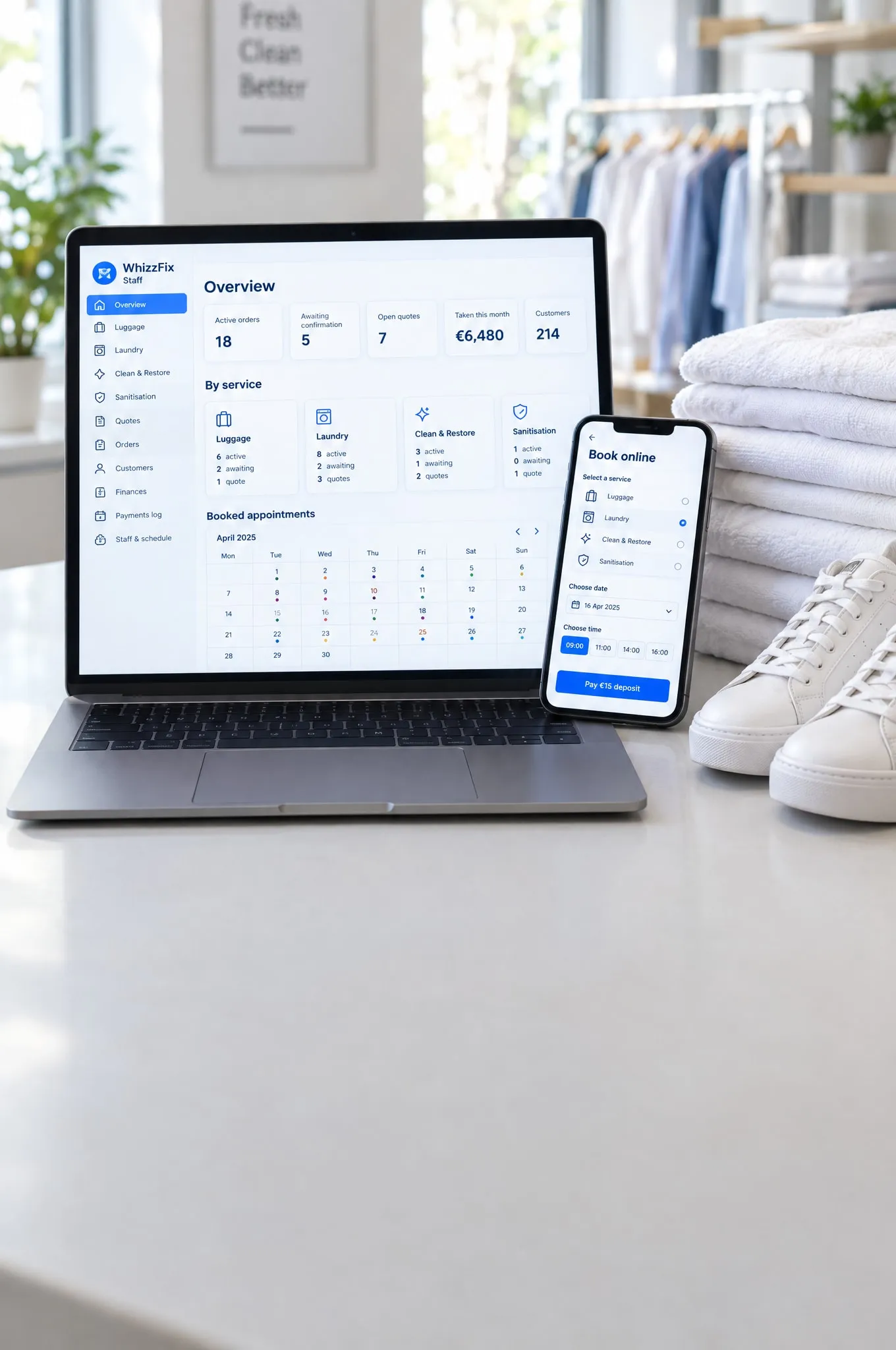A laptop showing the WhizzFix staff dashboard and a phone showing its booking form, beside folded laundry and white trainers